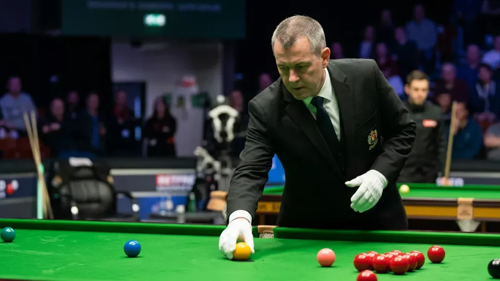Scheidsrechter plaatst een gekleurde bal terug op zijn spot op de snookertafel