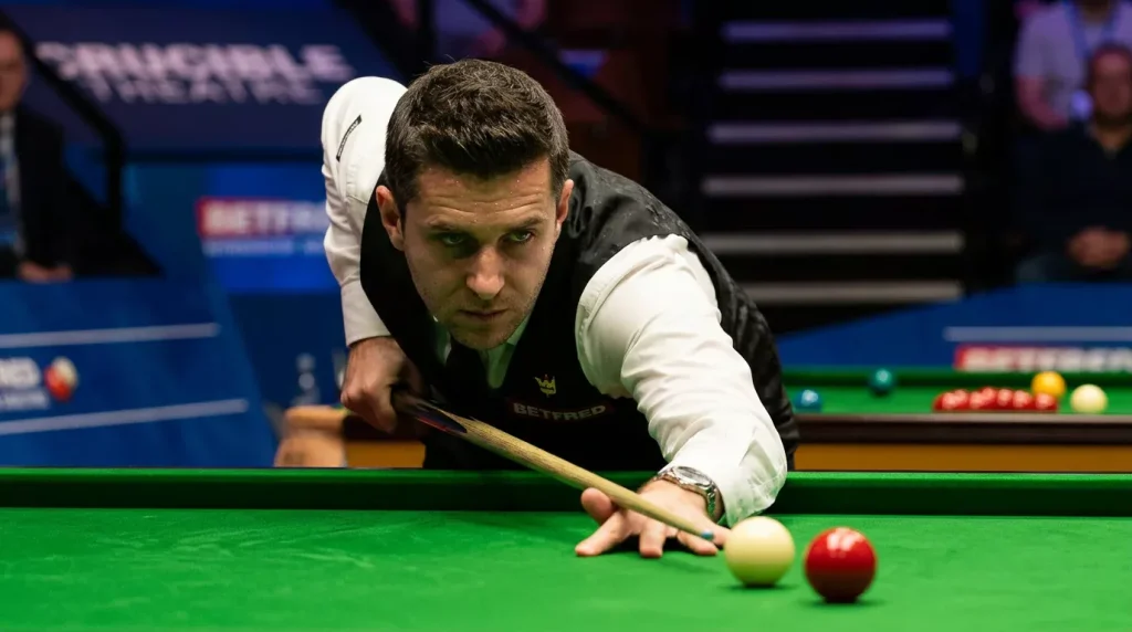 Snookerspeler leunt over de tafel en mikt op de volgende rode bal in het lopende frame
