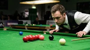 Snookerspeler bestudeert nauwkeurig de positie van de ballen voor zijn stoot
