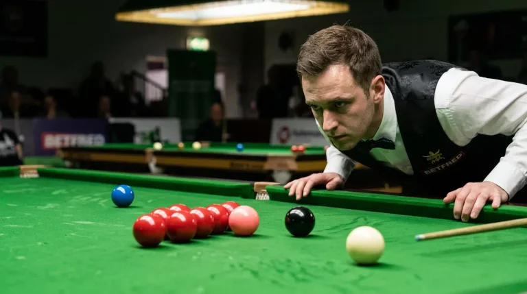 Snookerspeler bestudeert nauwkeurig de positie van de ballen voor zijn stoot
