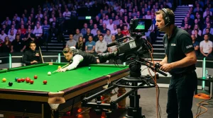 Cameraman filmt een snookerwedstrijd aan de rand van de verlichte tafel
