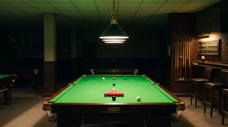 Rustige snookerzaal met een enkele verlichte tafel klaar voor het spel